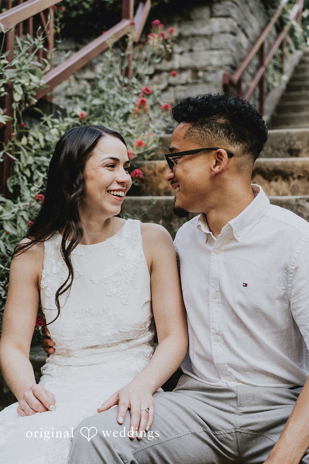 Seated couple smiling and looking lovingly at each other.