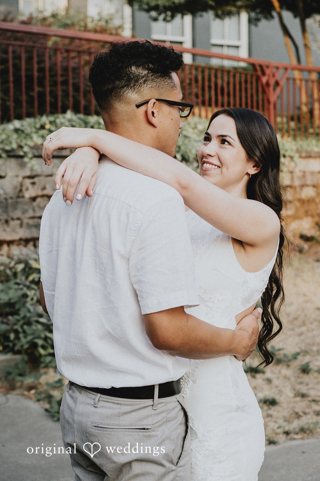 Woman wrapping her arms around a man's neck in a warm embrace.