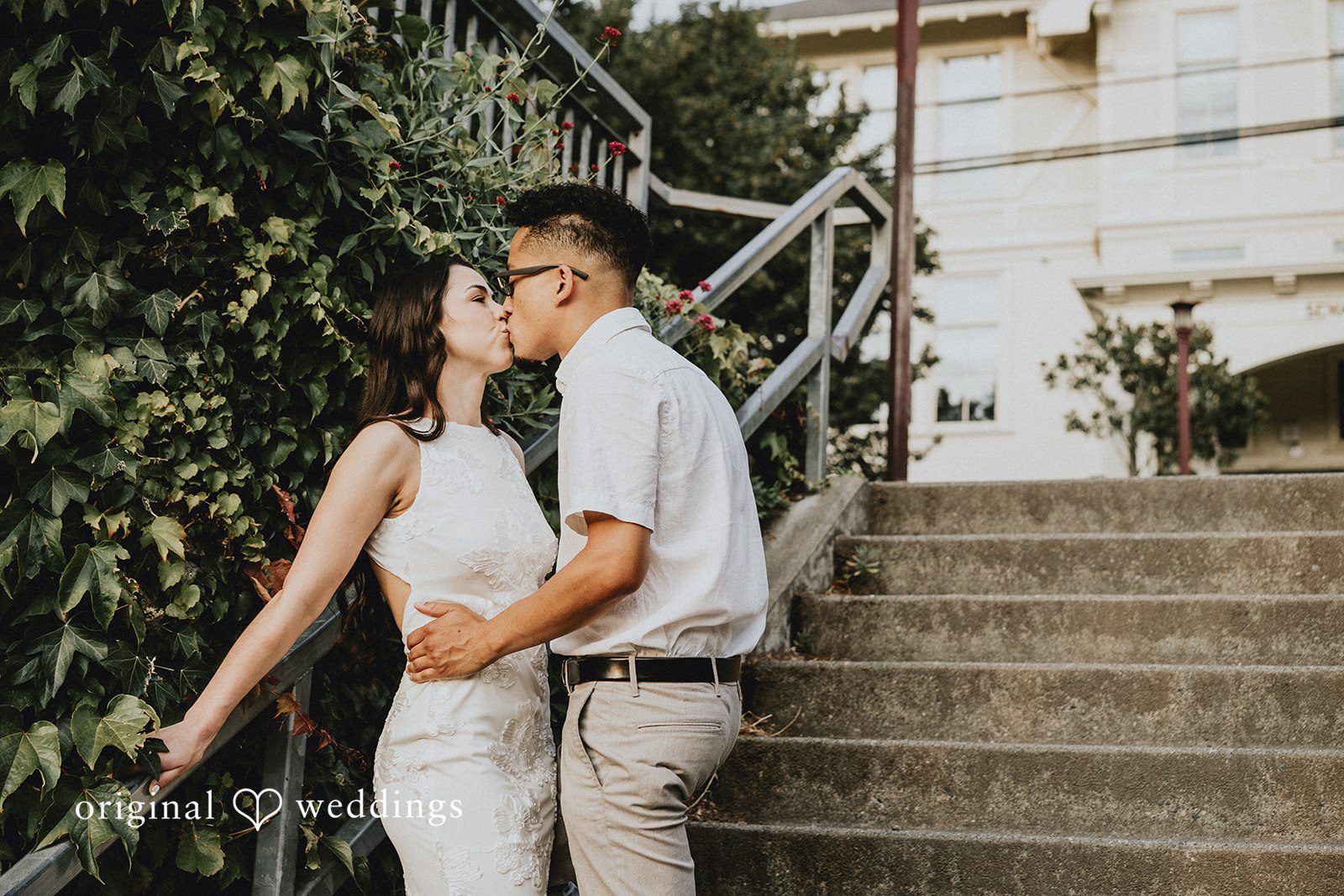 Couple embracing each other while standing on a set of stairs.