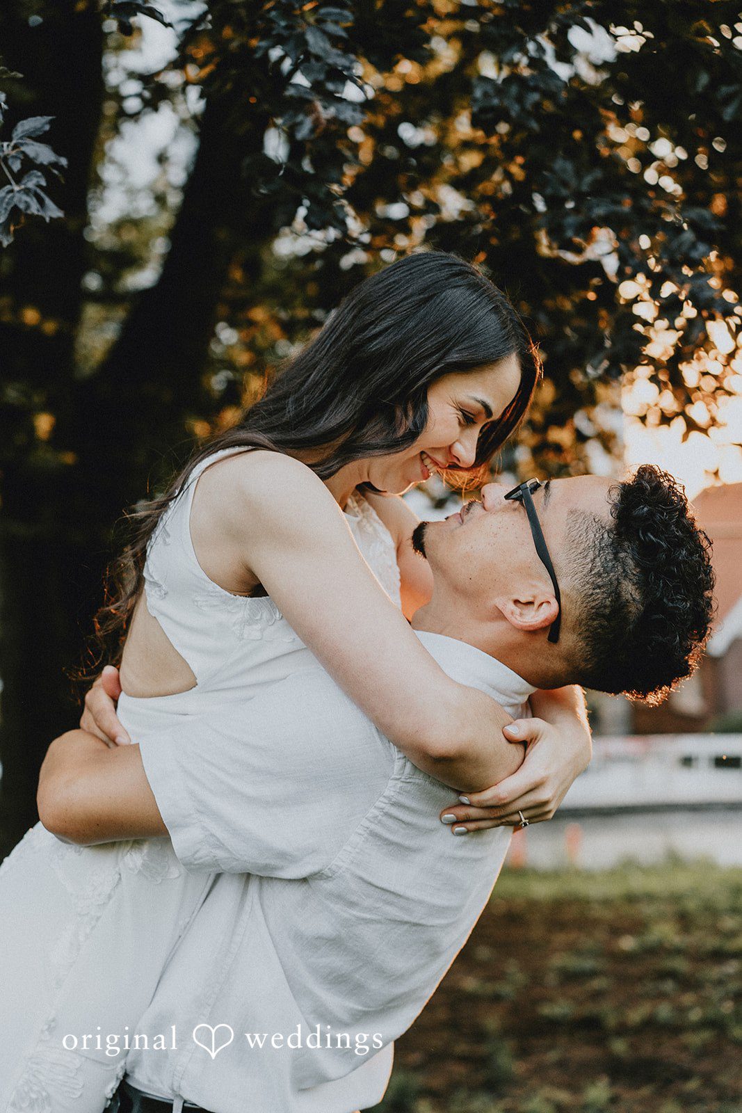 Man playfully lifting and dipping a woman in a joyous embrace.
