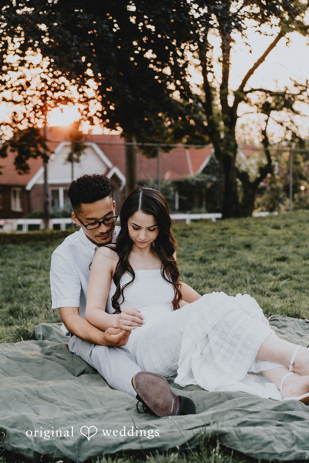 Couple sitting together and relaxing on a green grassy lawn.