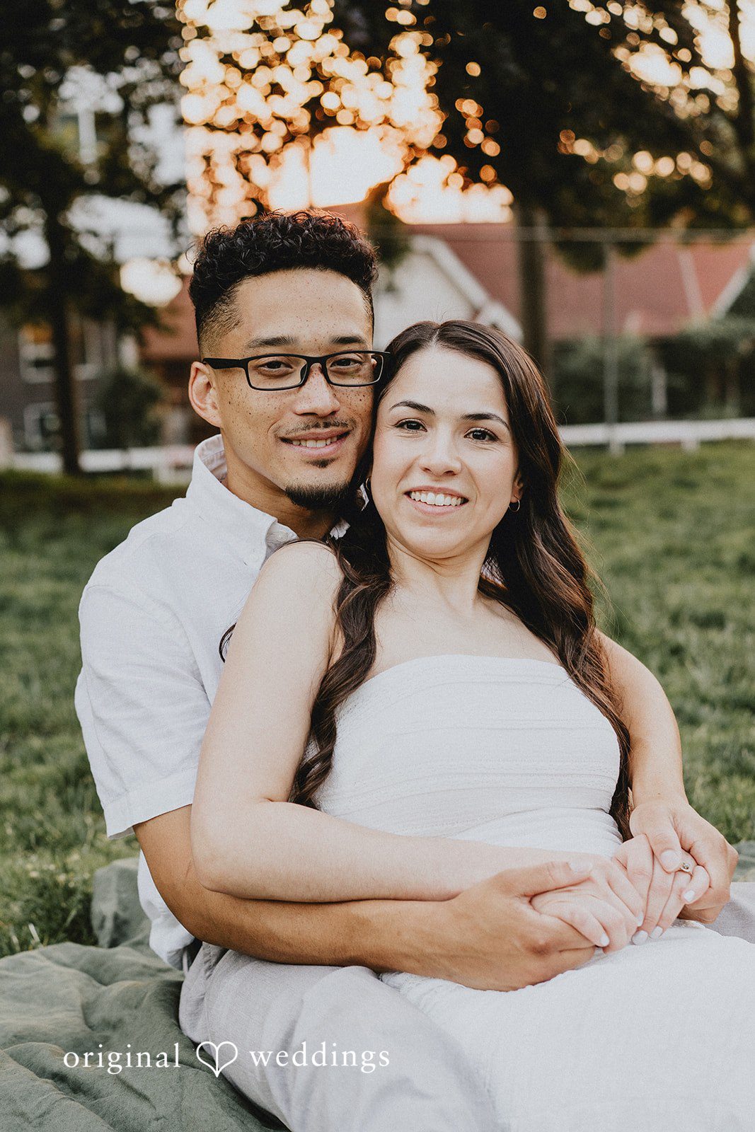 Man leaning in close to a smiling woman while holding her from behind.