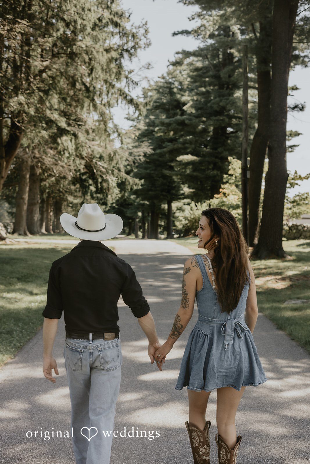 Meghan + Kal Couple walk hand-in-hand down a path away from the camera.