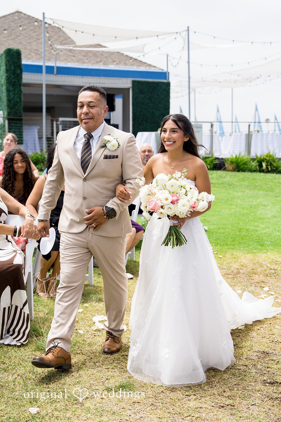 Kalina + Malakai A bride and man walking hand-in-hand down the aisle following their ceremony.