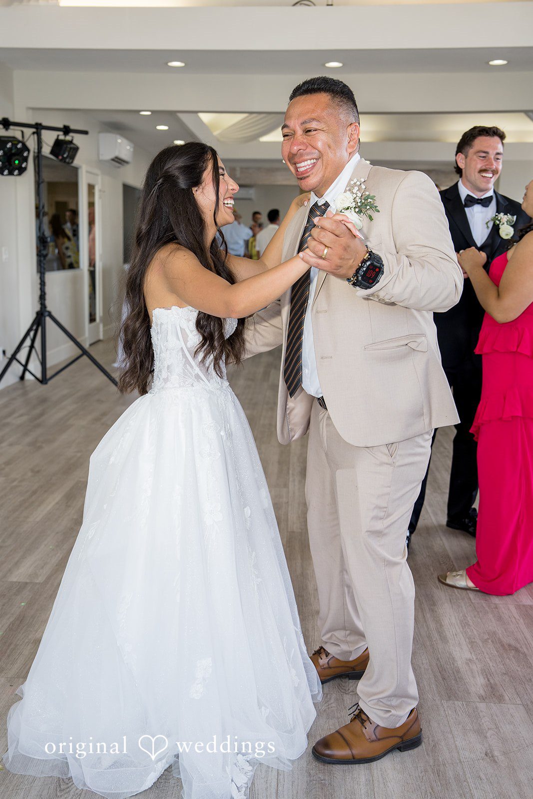 Kalina + Malakai A bride dancing happily with a guest wearing a light-colored suit during the reception.