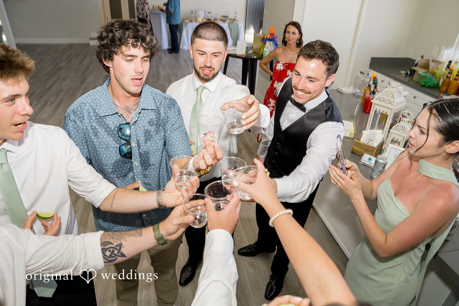 Kalina + Malakai Group of wedding guests raising their glasses for a celebratory toast.