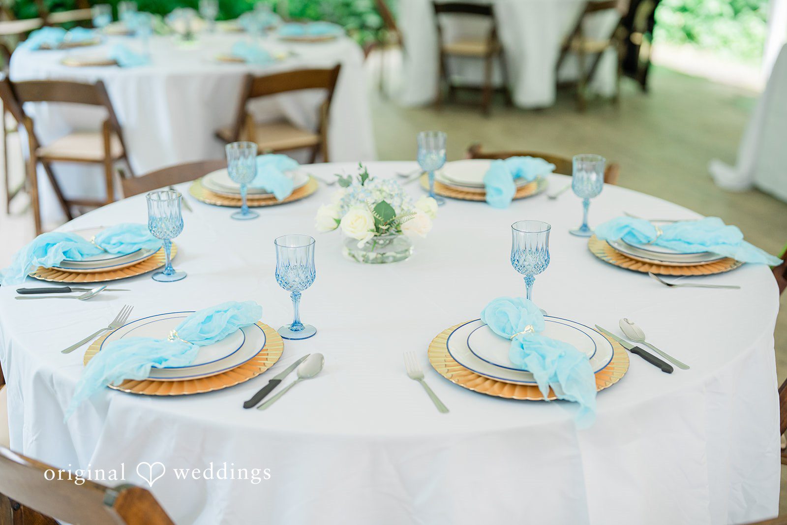 Destiny + Maksim A decorated round wedding table with light blue and white linens.
