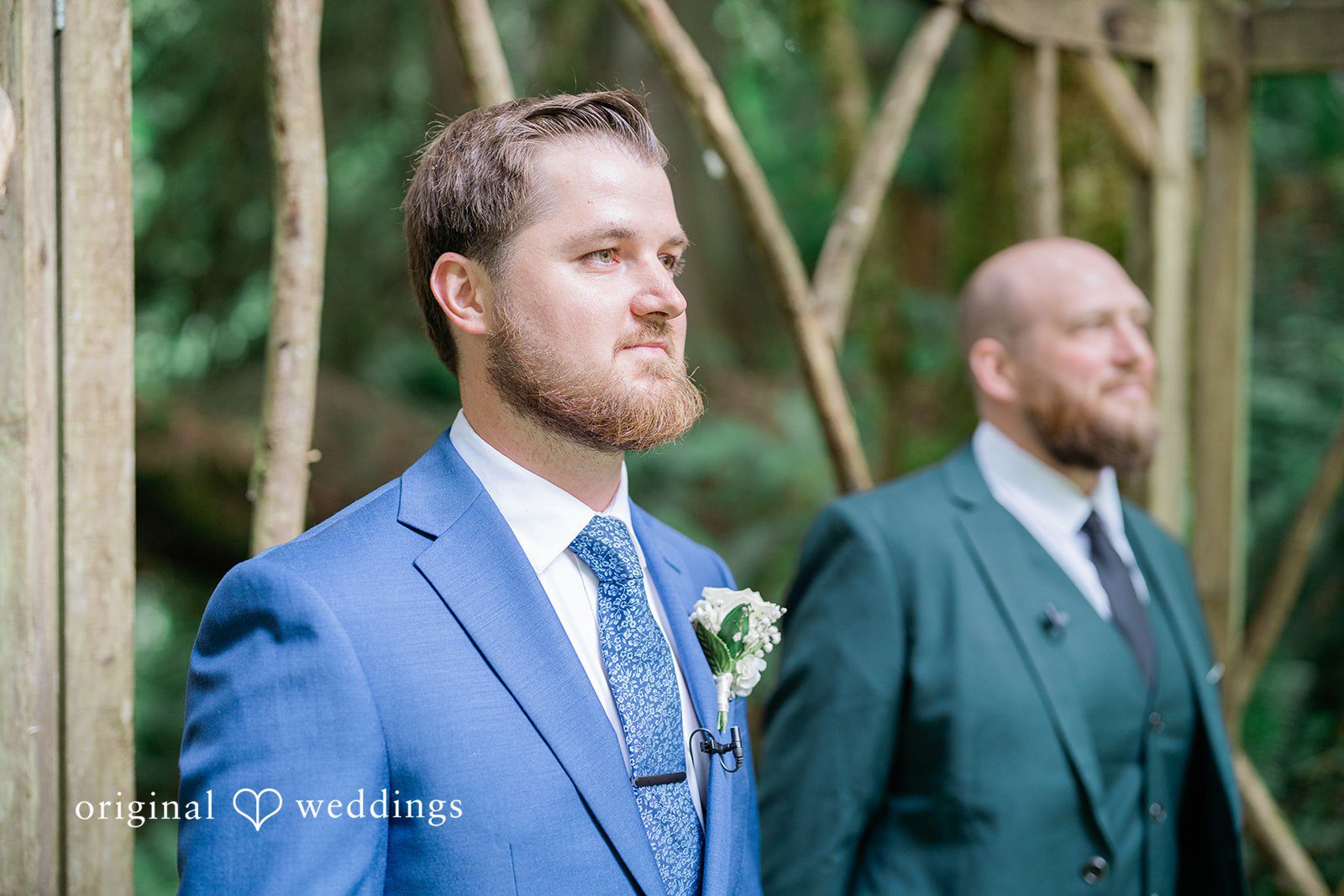 Destiny + Maksim A groom in a blue suit smiling while standing alongside his groomsmen.