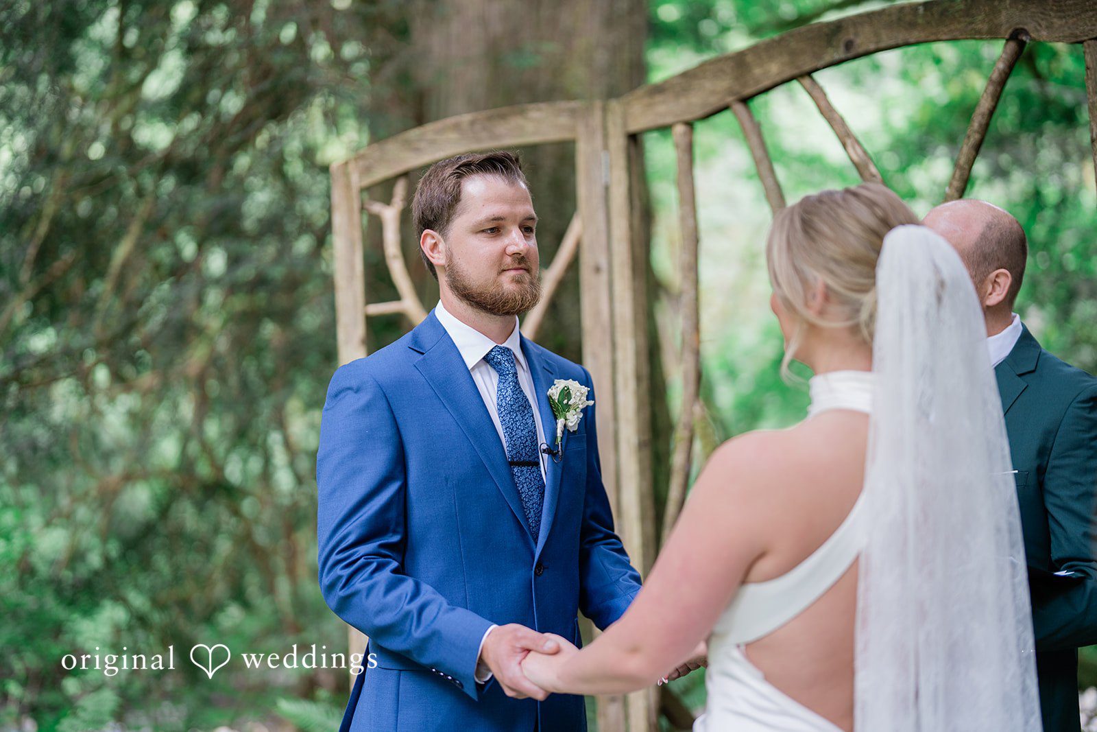 Destiny + Maksim A bride and groom holding hands and looking at each other during their ceremony.
