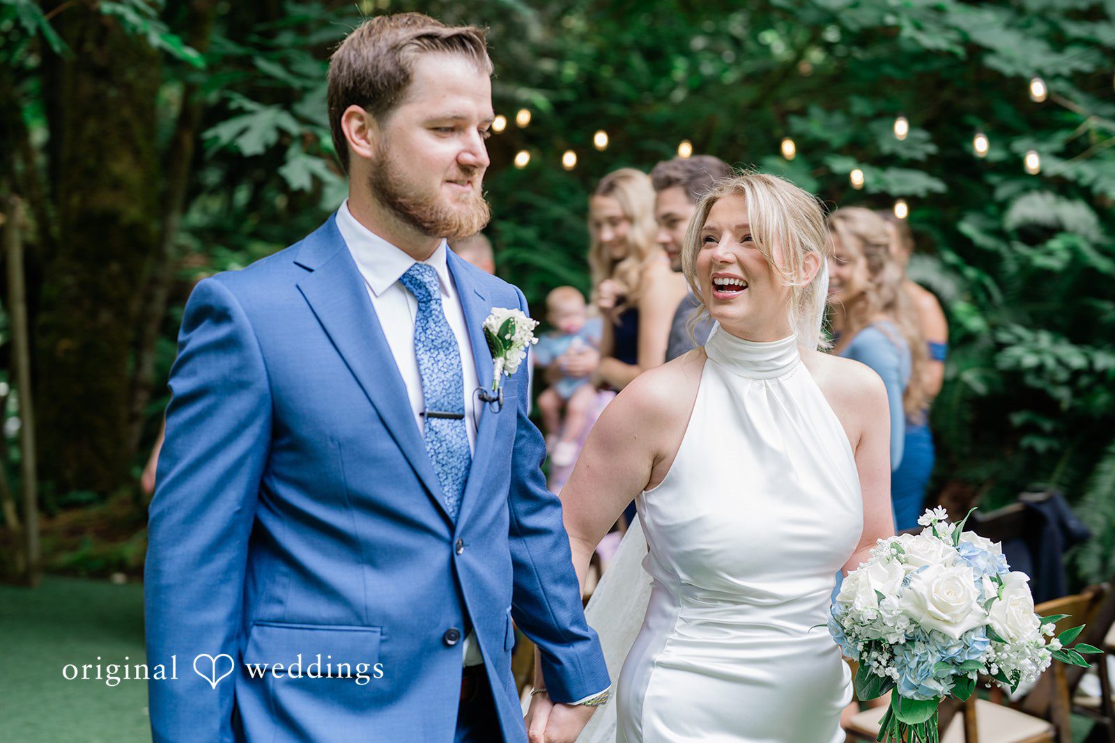 Destiny + Maksim A smiling bride and groom walking down the aisle together as newlyweds.