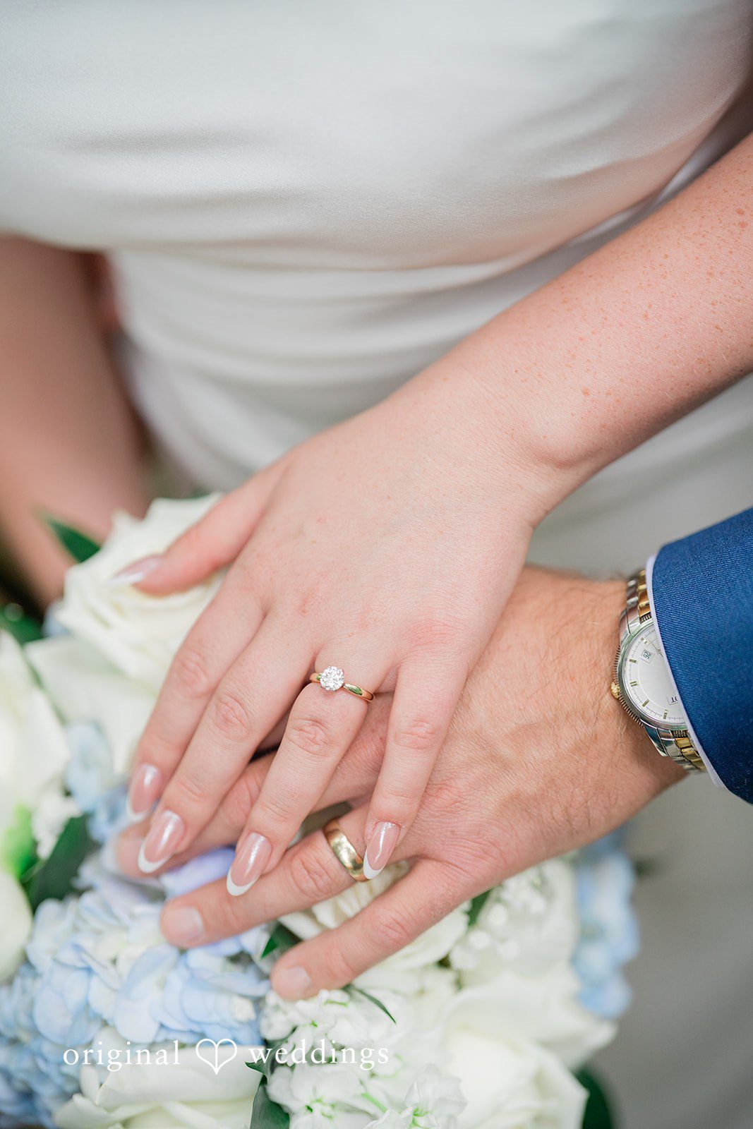 Destiny + Maksim A close-up of a bride and groom's hands showing off their wedding rings.