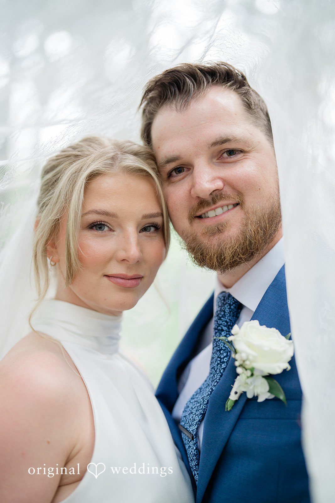 Destiny + Maksim A close-up portrait of a smiling bride and groom standing close together.
