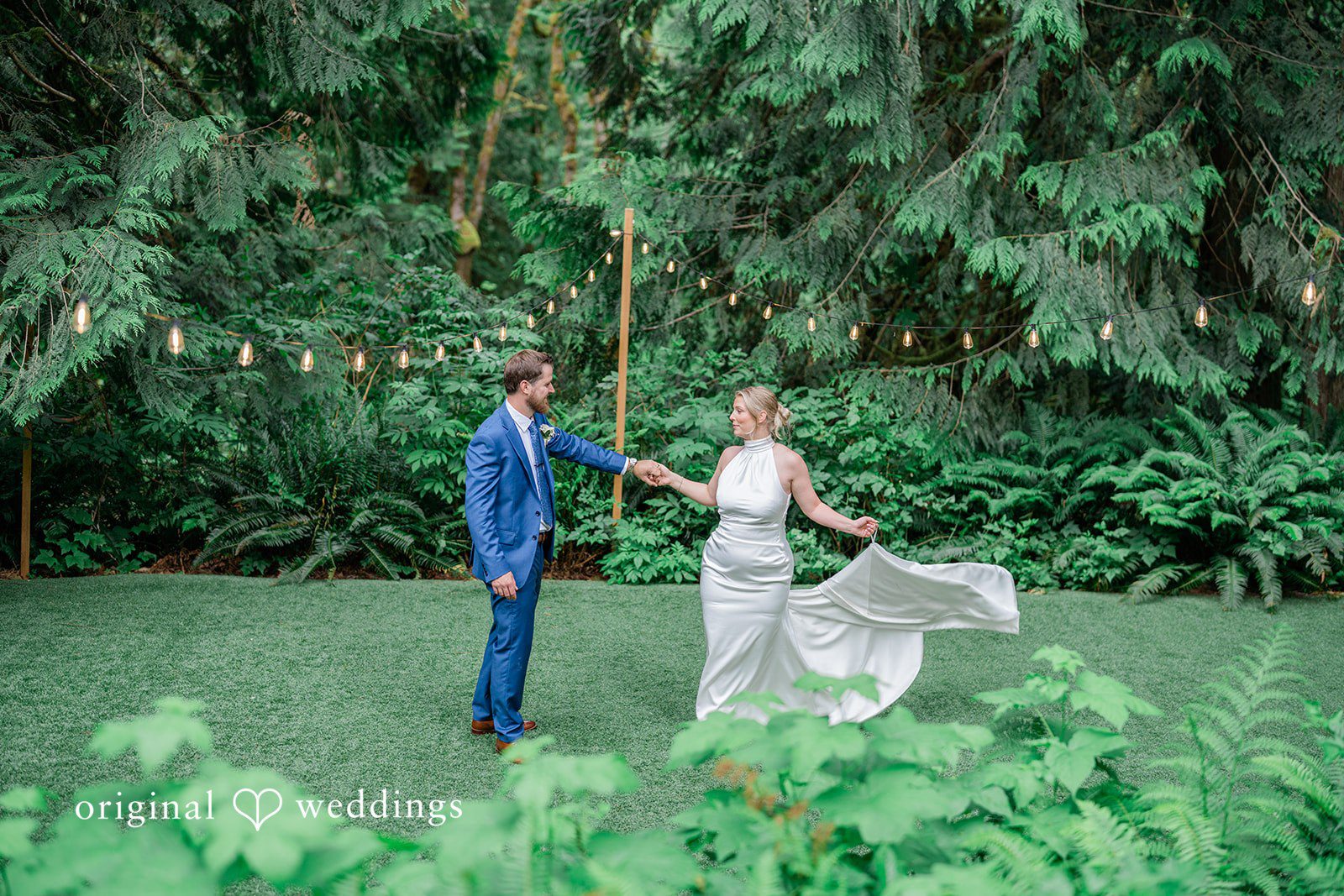 Destiny + Maksim A bride and groom holding hands and walking together across a green lawn.