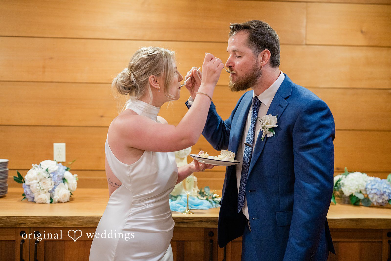 Destiny + Maksim A bride and groom feeding each other a slice of wedding cake.