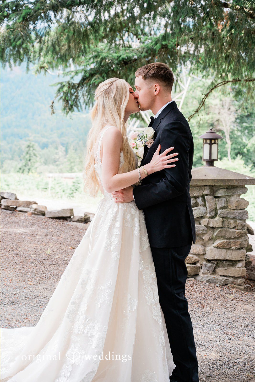 Luke + Kelsey A bride and groom embracing on a stone balcony.
