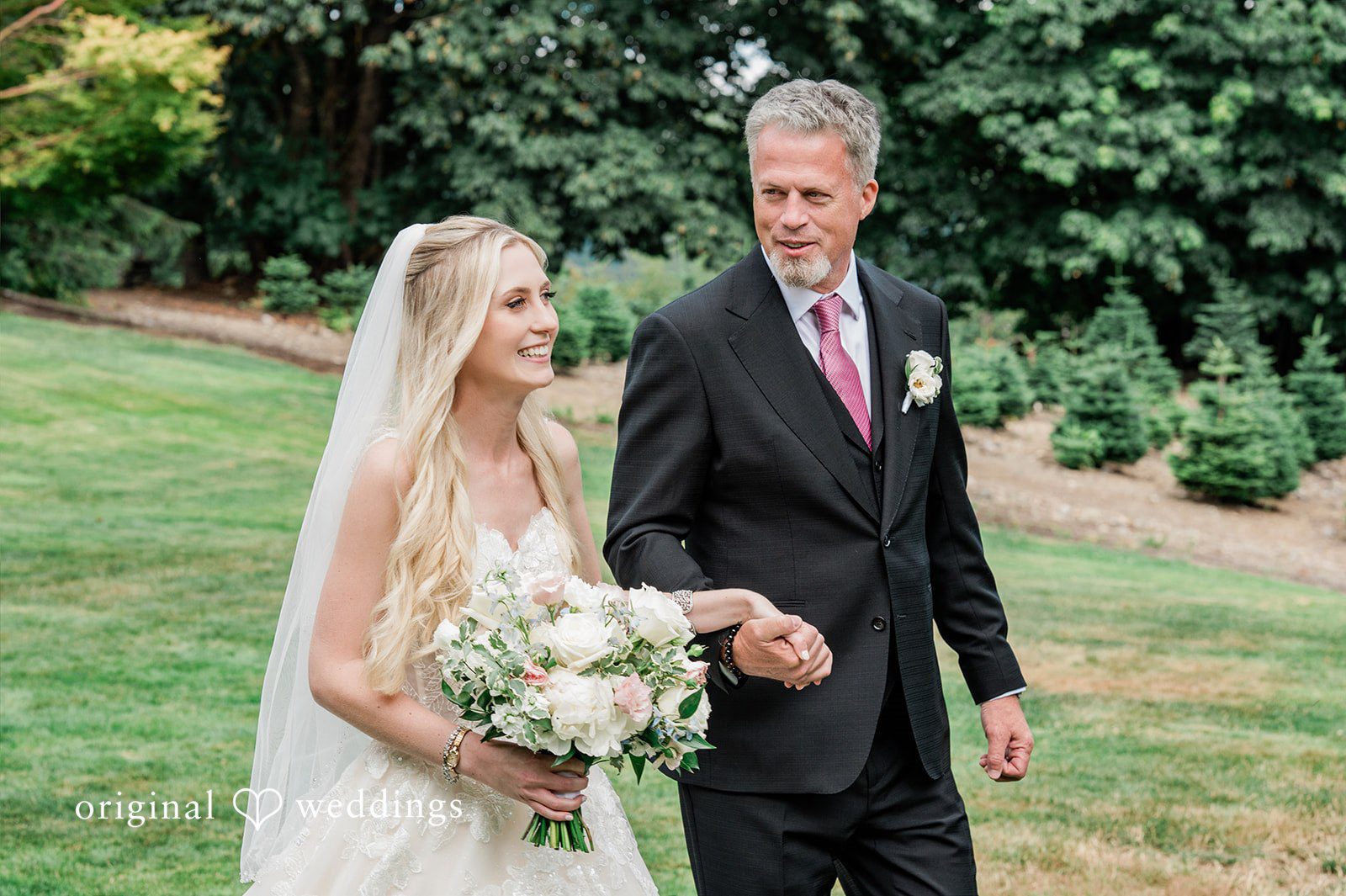 Luke + Kelsey A bride and man walking down a path while holding hands