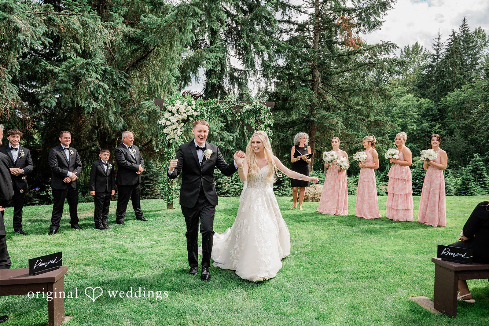 Luke + Kelsey A bride and groom walking hand-in-hand down the aisle after the ceremony.