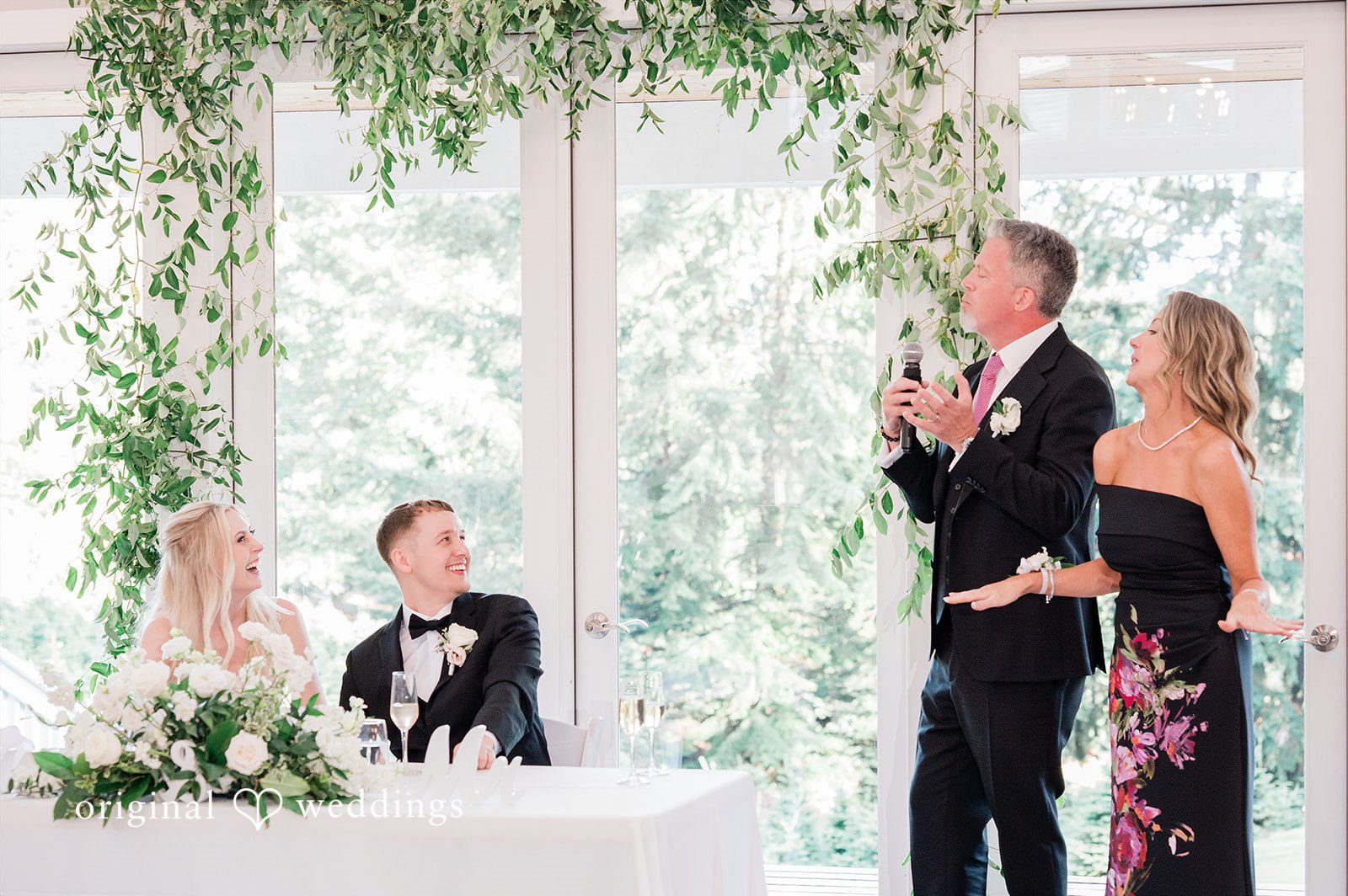 Luke + Kelsey A bride and groom sitting at a decorated reception.