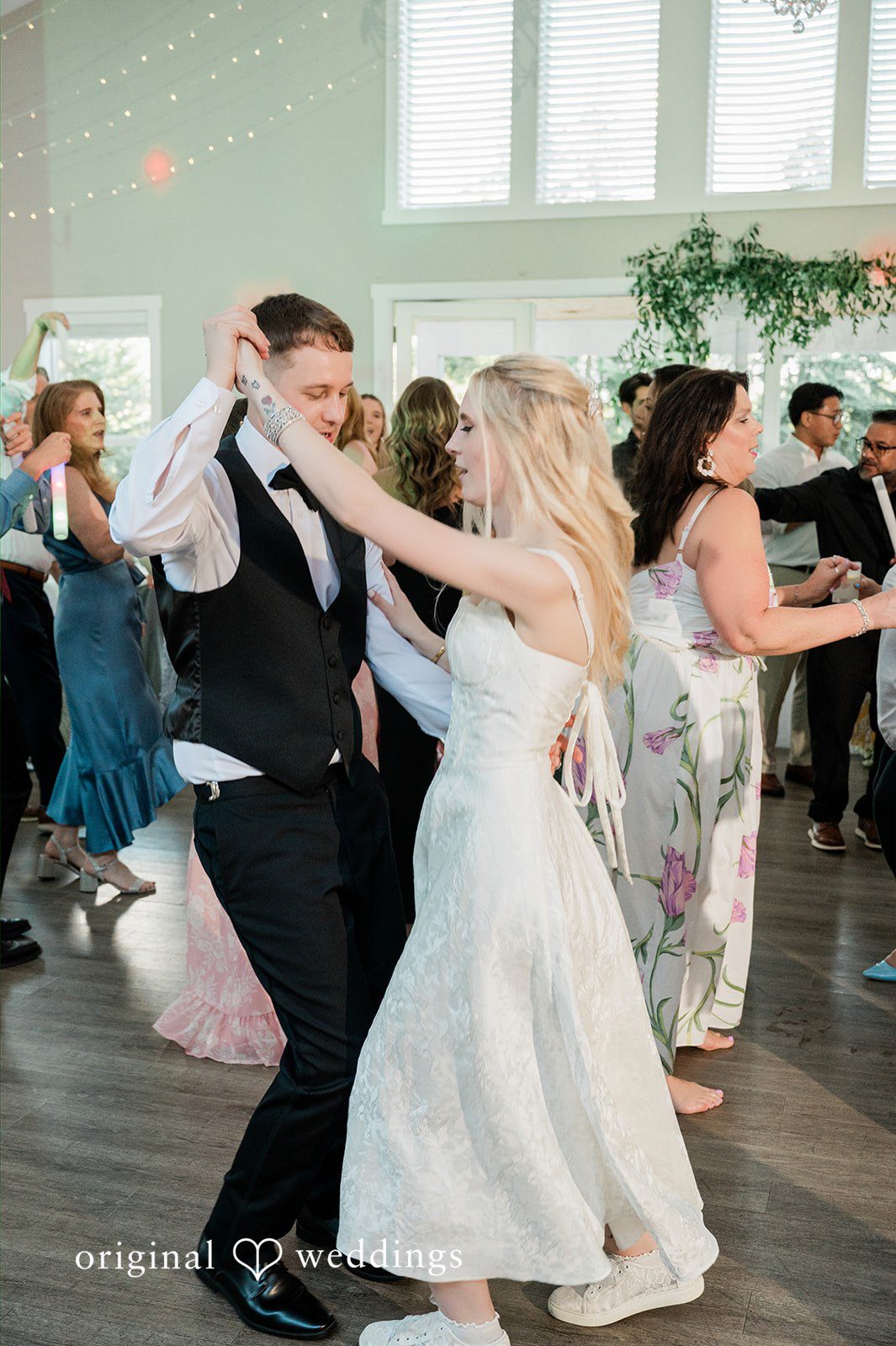 Luke + Kelsey A bride and groom dancing energetically with their wedding guests.