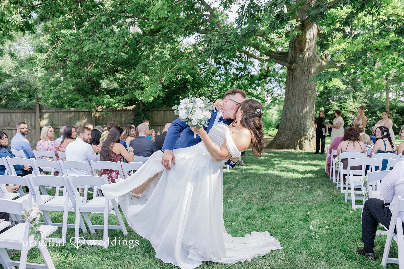 Emily + Joshua Bride and groom sharing a romantic wedding kiss.
