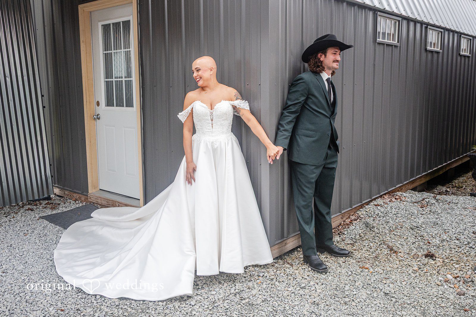Savannah + Phillip A bride and groom holding hands and walking next to a gray corrugated metal building.