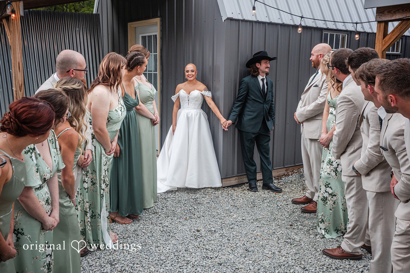 Savannah + Phillip A wedding party walking together down a gravel path lined by a wooden fence.