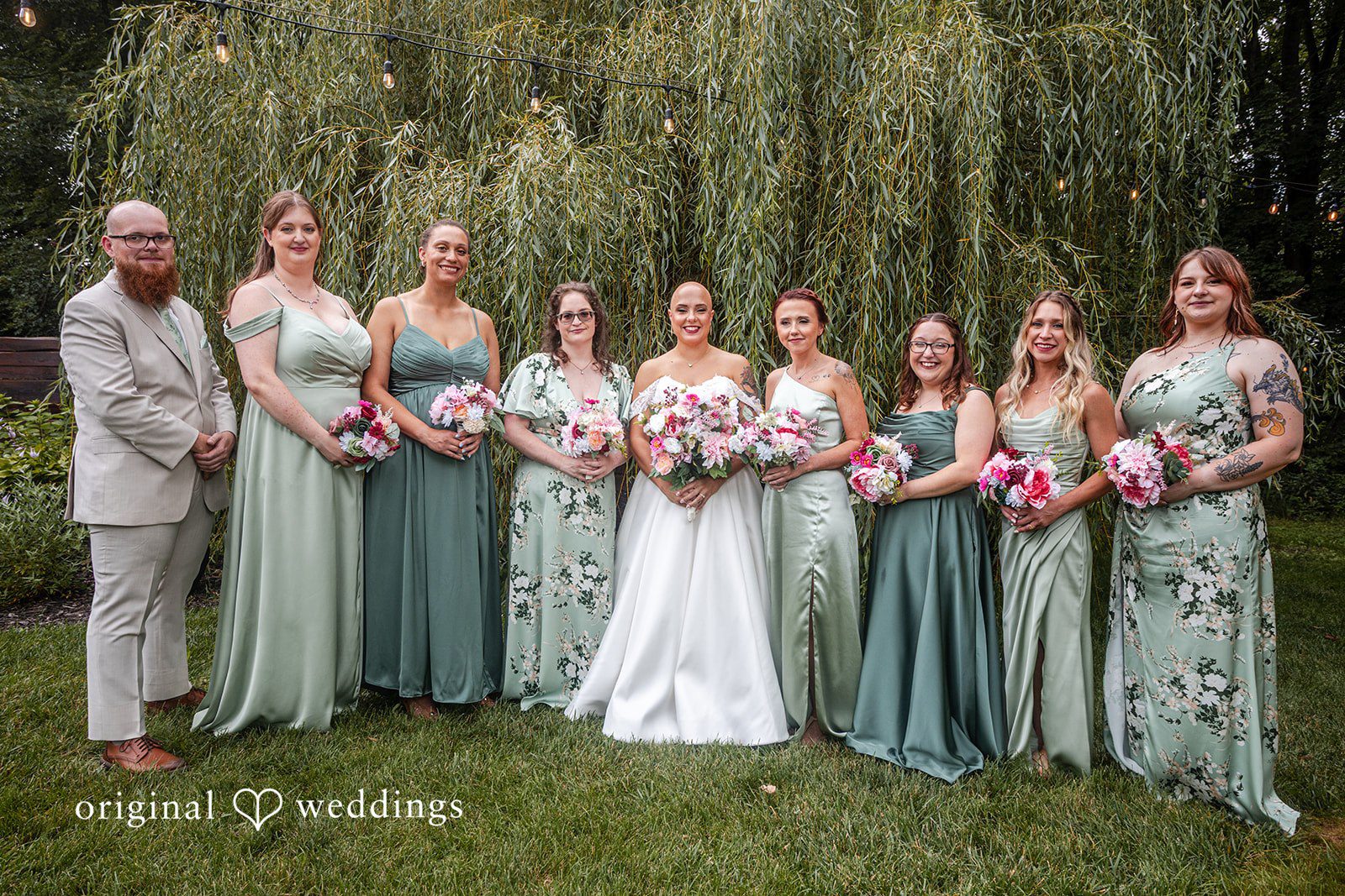 Savannah + Phillip A bridal party featuring bridesmaids in sage green dresses and all are posing together.