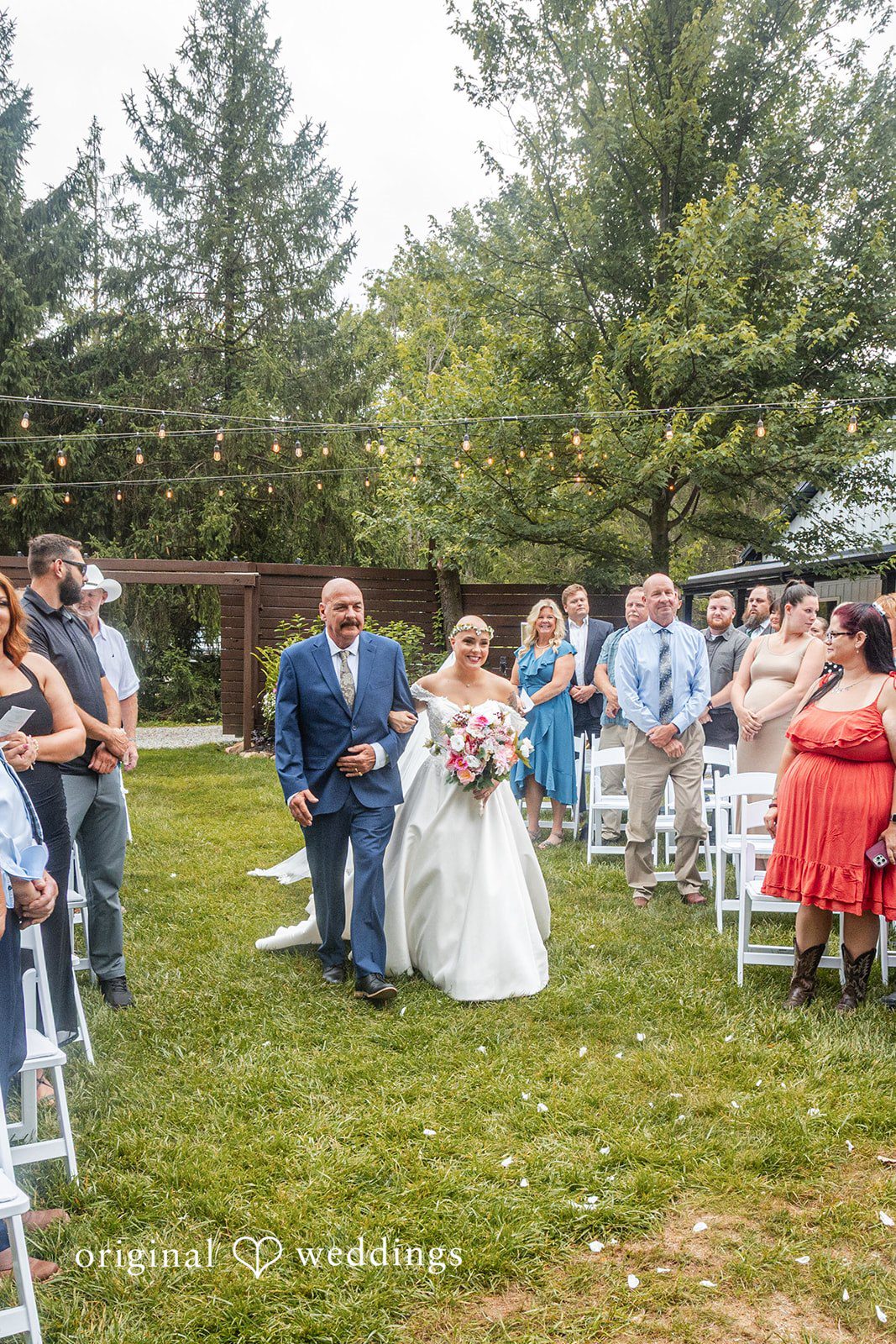 Savannah + Phillip A wide view of wedding guests seated in rows of chairs during a ceremony.