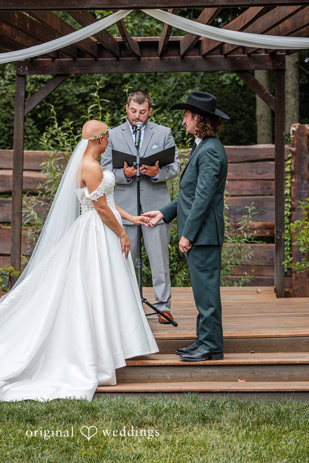 Savannah + Phillip A bride and groom standing at a rustic wooden altar during their wedding ceremony.