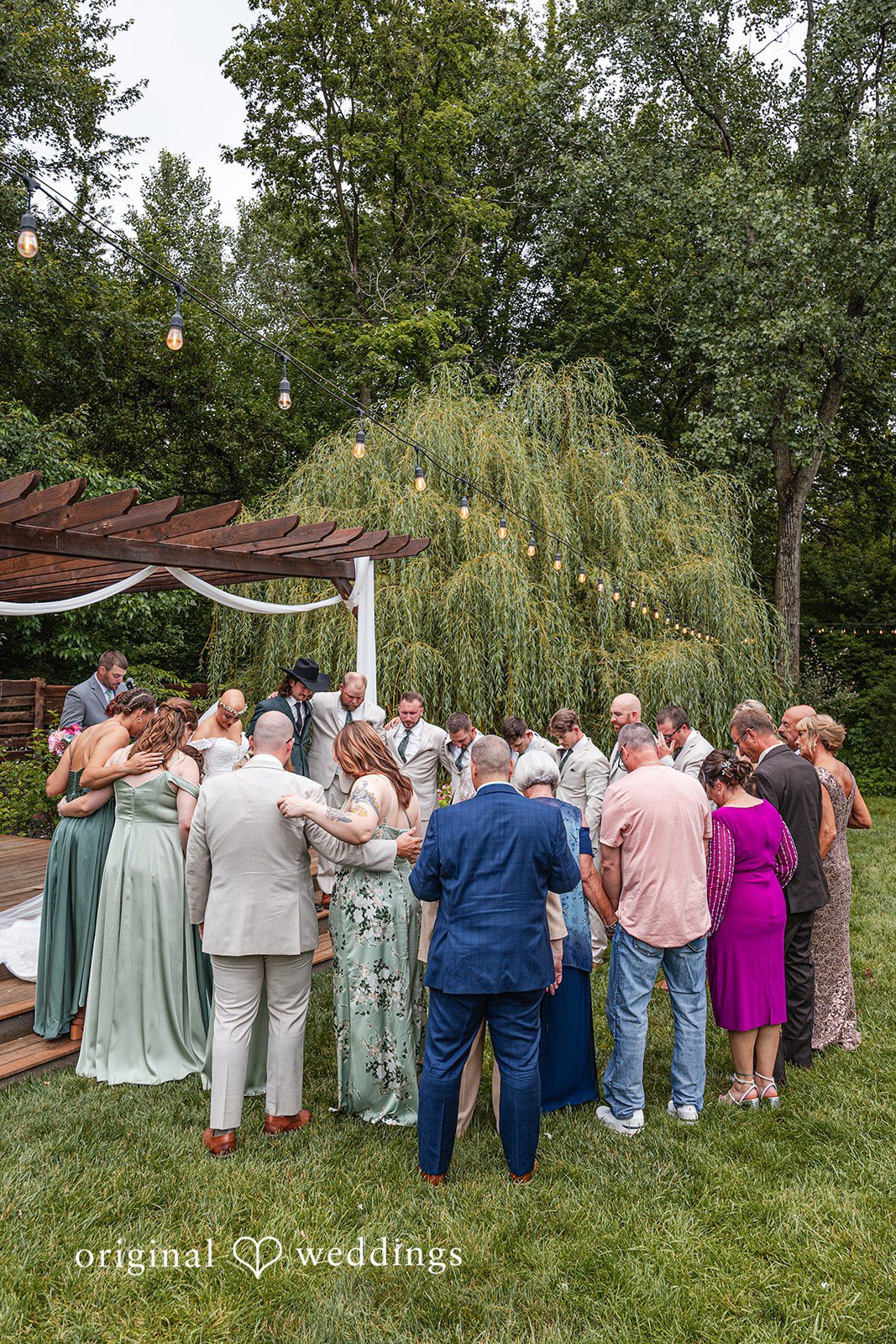 Savannah + Phillip A large group of wedding guests gathered in a circle on a lawn during a reception.