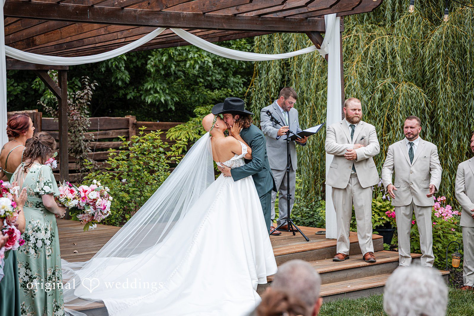 Savannah + Phillip A bride and groom standing at the altar surrounded by their wedding party during the ceremony.
