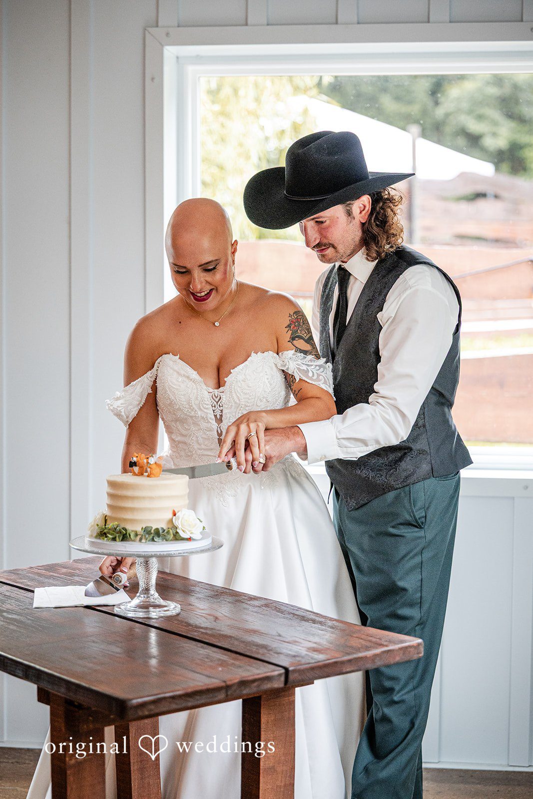 Savannah + Phillip A bride and groom cutting their wedding cake together at a reception table.