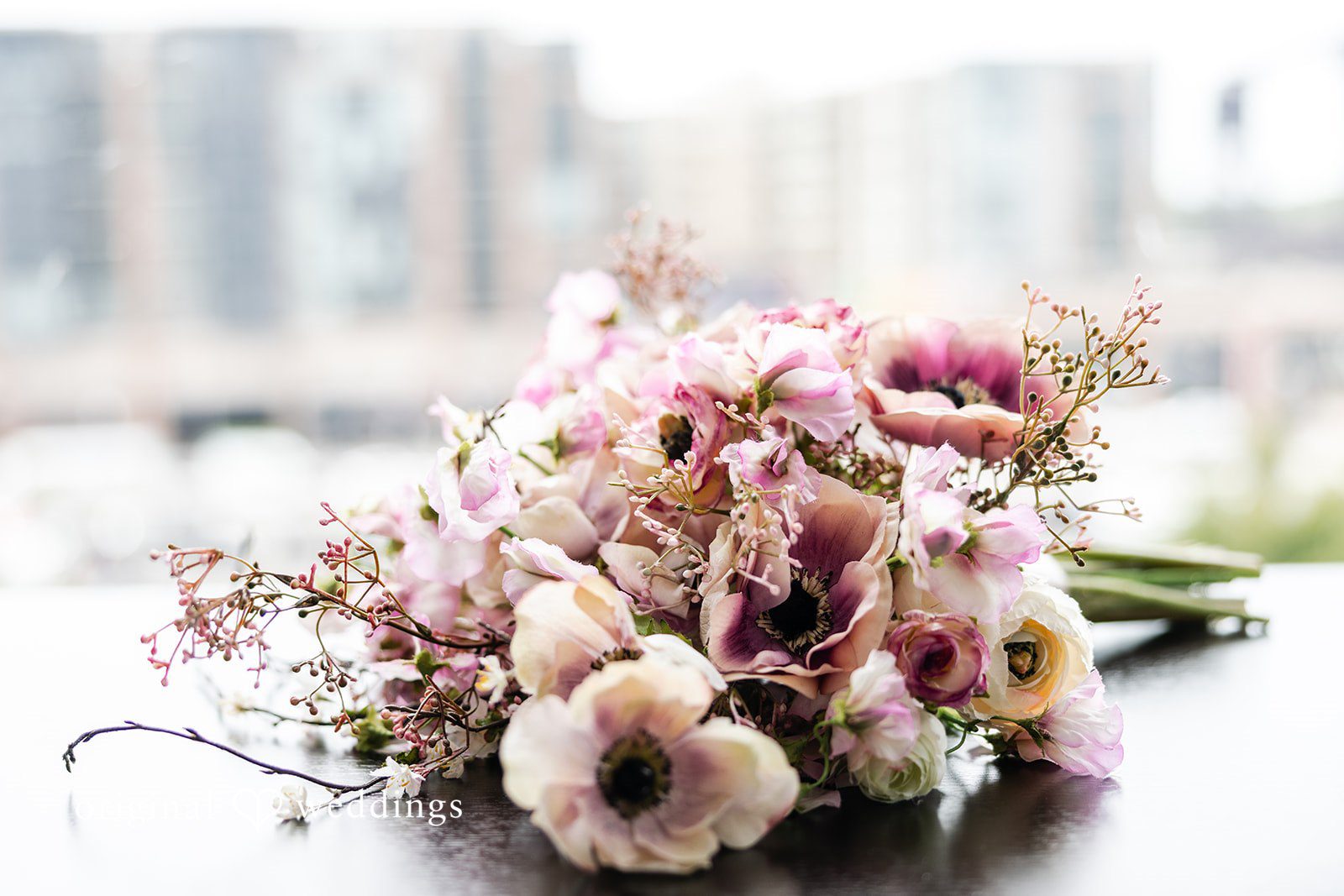 Dan + Alex A bouquet of soft pink and white flowers arranged in a low vase.