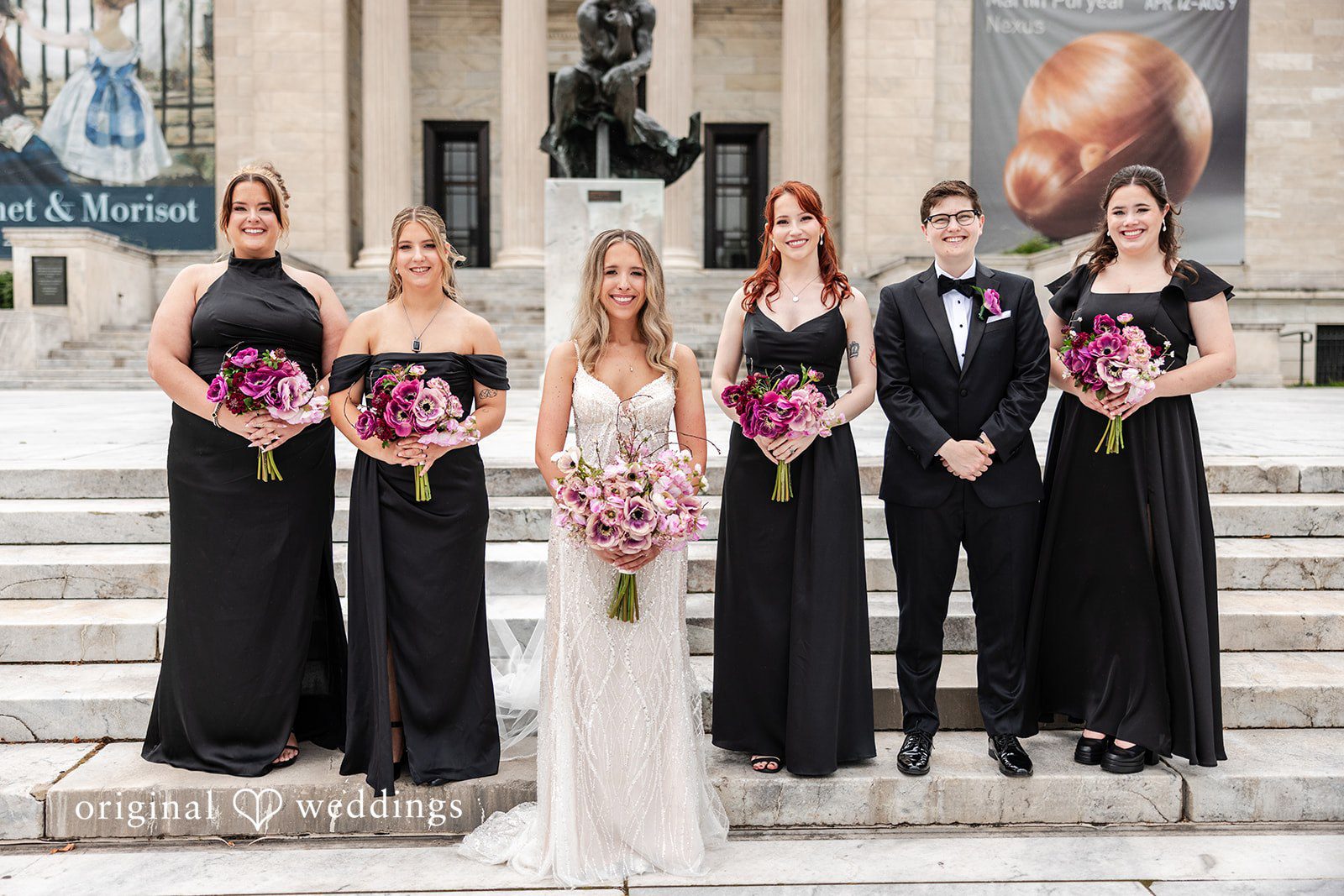 Dan + Alex A full wedding party posing together, with bridesmaids in black dresses