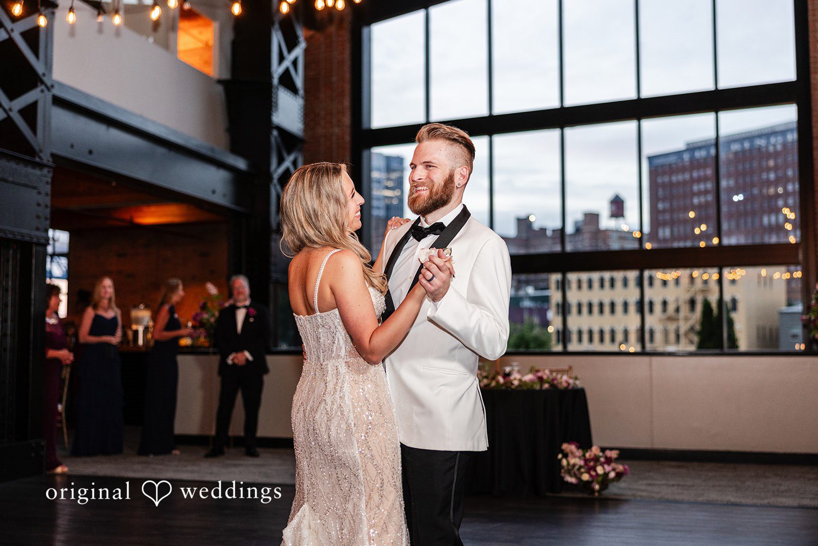 Dan + Alex A bride and groom sharing a dance on an open floor in a modern venue.