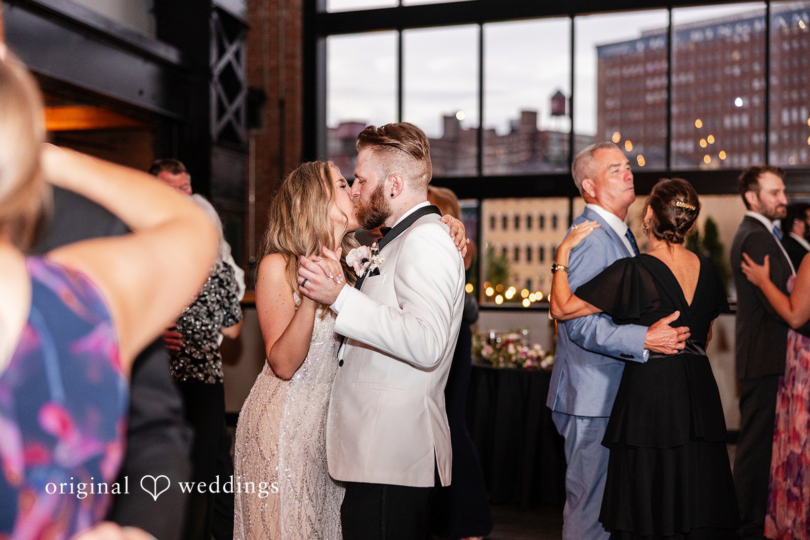 Dan + Alex Multiple wedding guests dancing together on a lively dance floor.