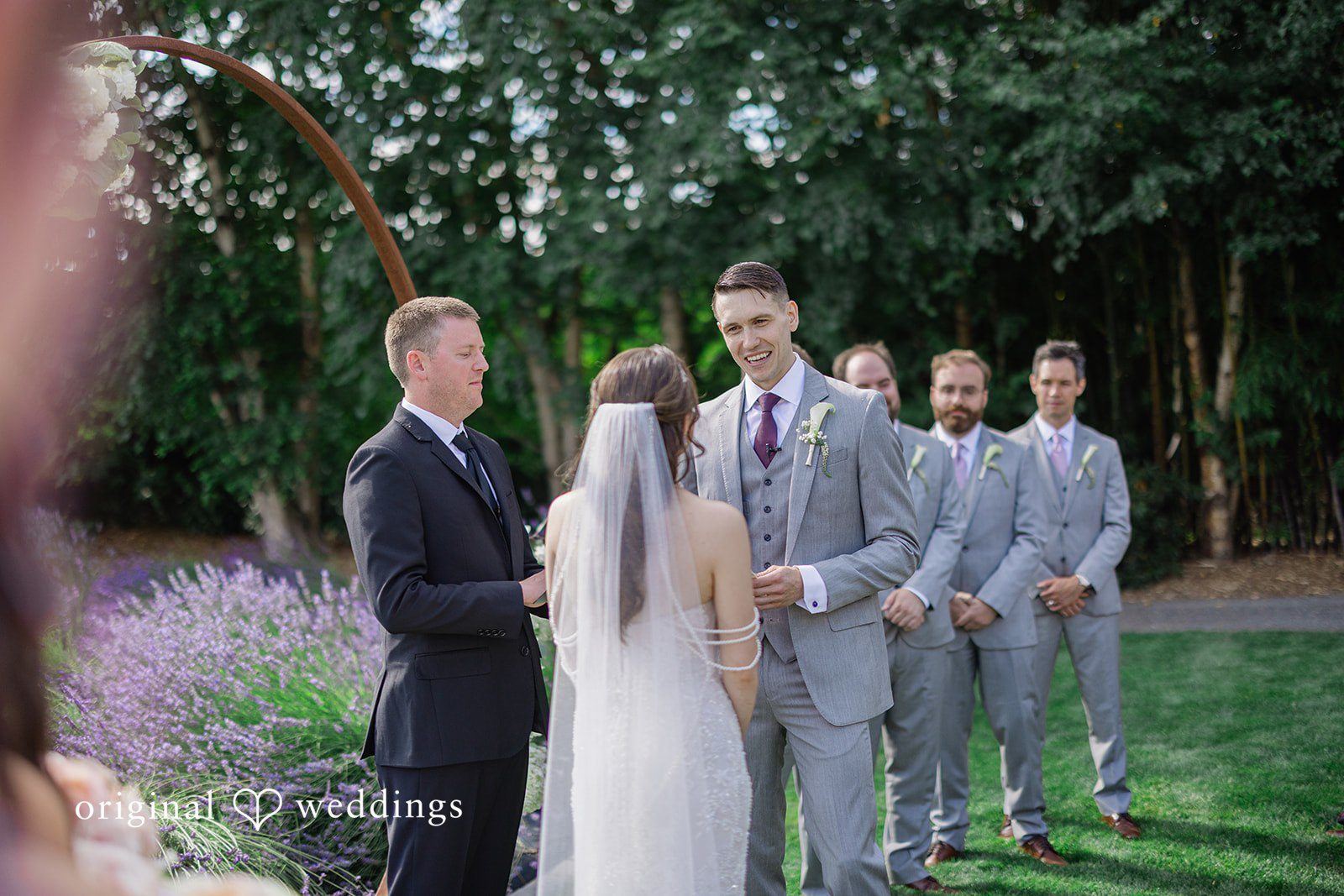 Veronica + Andrew A wedding couple standing together during their ceremony in front of groomsmen.