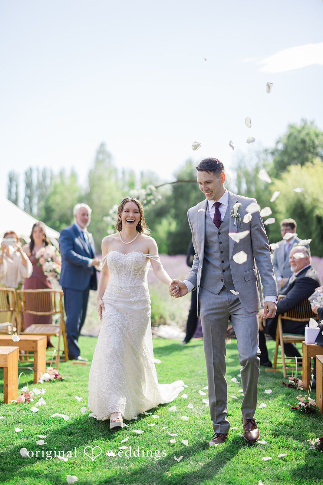 Veronica + Andrew A newlywed couple walking down the aisle together while guests applaud.