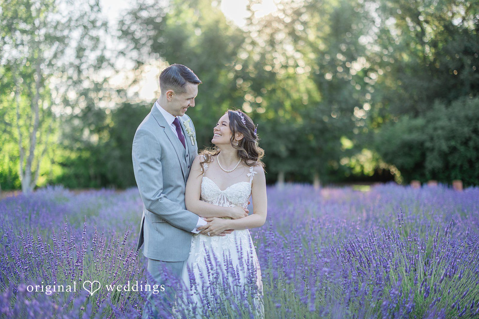 Veronica + Andrew A groom and bride stand facing each other lovingly in a lavender field.