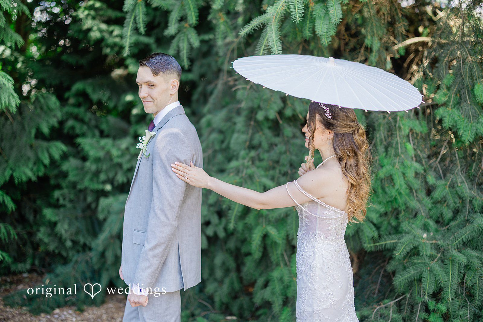 Veronica + Andrew A bride reaches out toward the groom while holding a white parasol.
