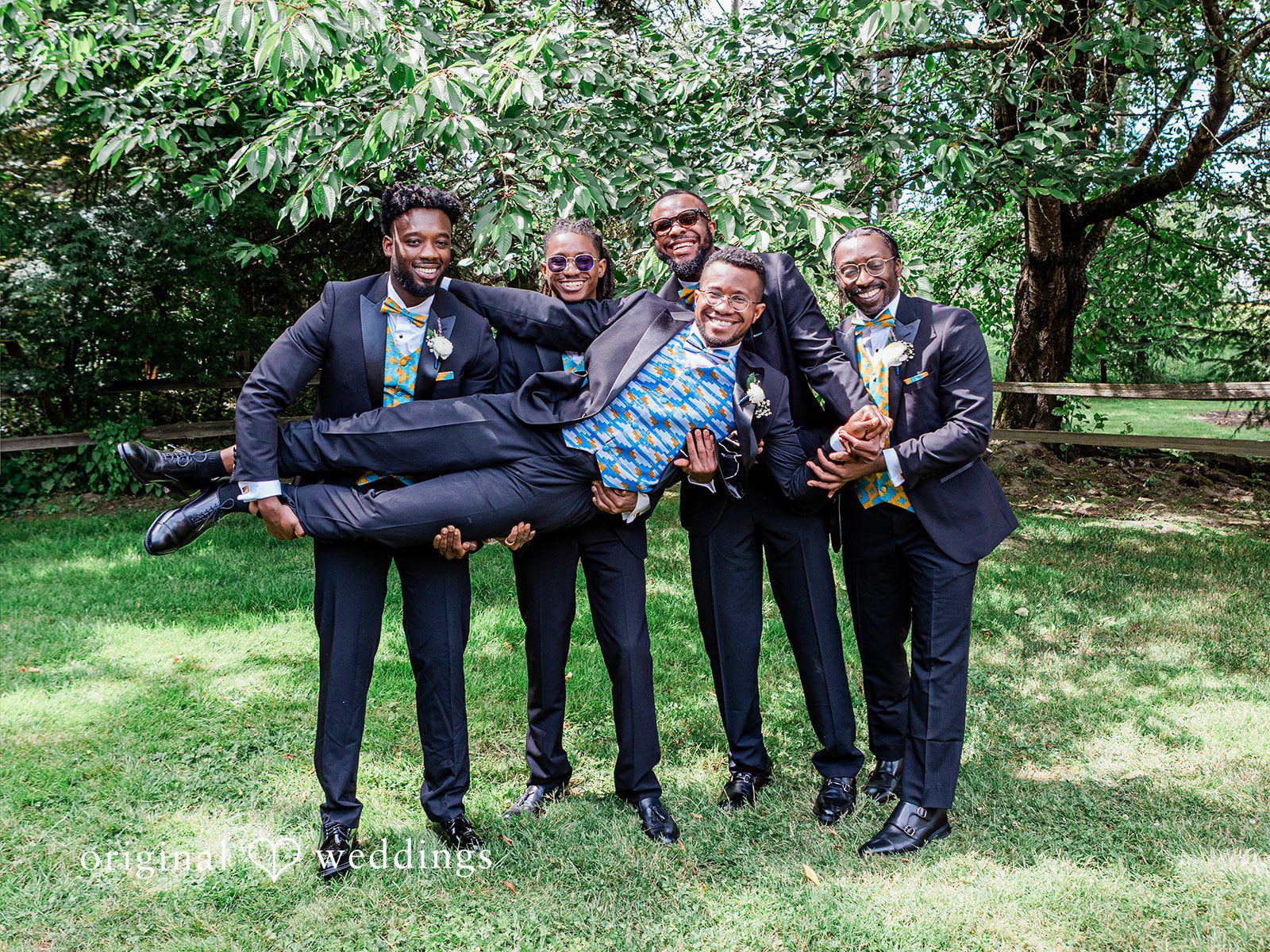 Katrina + Japhet Group of groomsmen in suits playfully posing togethre.