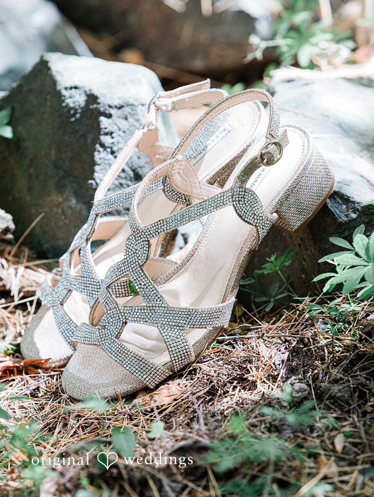 Katrina + Japhet Close-up shot of white bridal high heel shoes decorated with sparkling rhinestones.