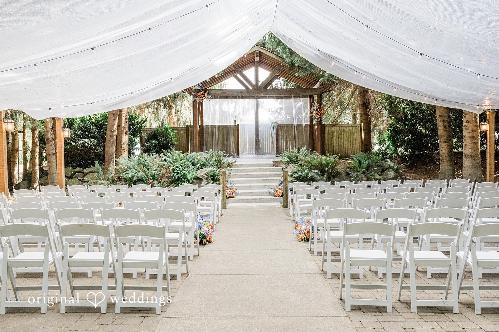 Katrina + Japhet Wedding aisle with white chairs under a canopy.