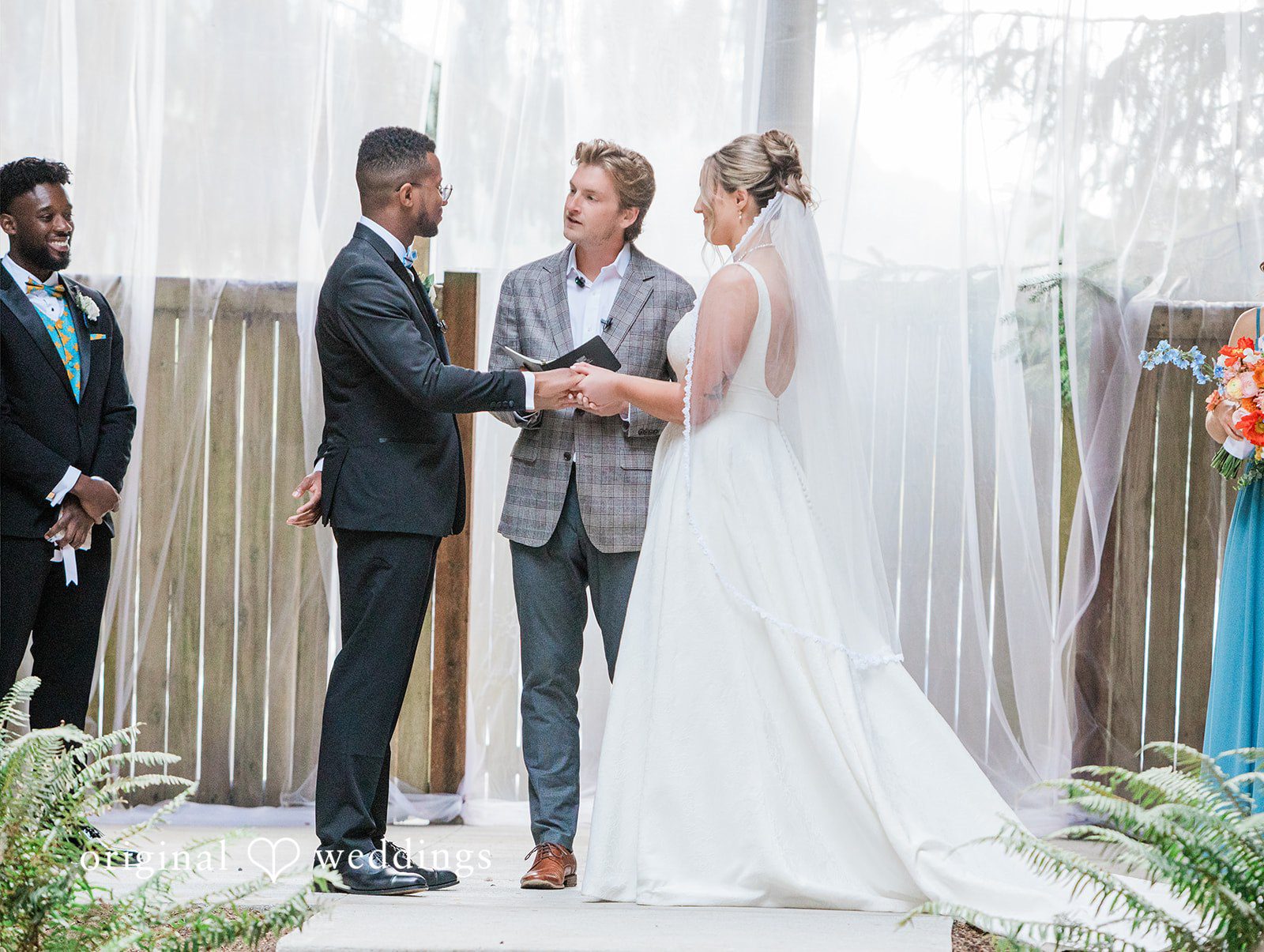 Katrina + Japhet Bride and groom facing each other while a wedding officiant speaks during the ceremony.