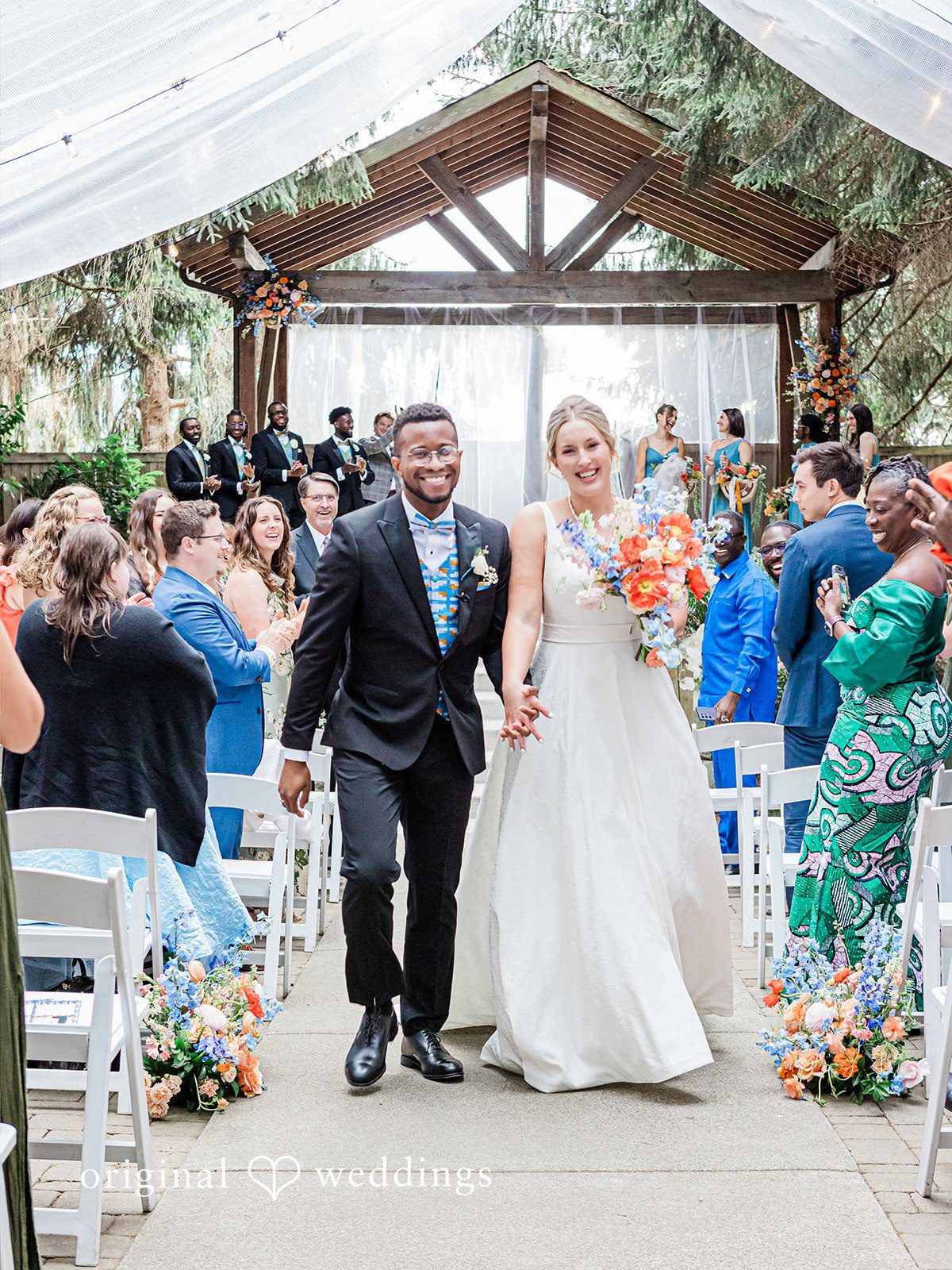 Katrina + Japhet Newly married bride and groom smiling while walking down the aisle together after the ceremony.