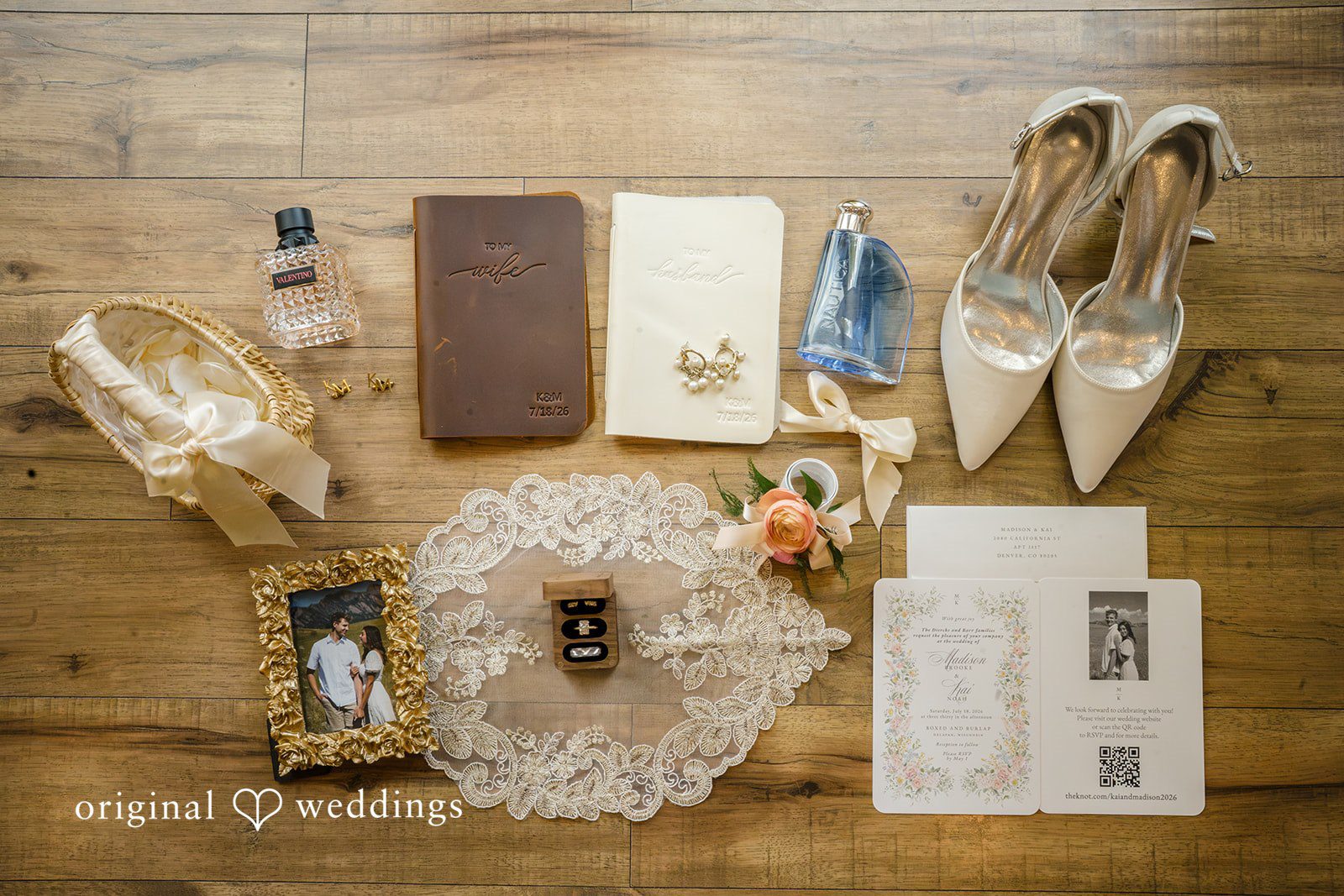 A bridal flat-lay displays wedding shoes, invitation stationery, a floral wreath, and accessories on wood.