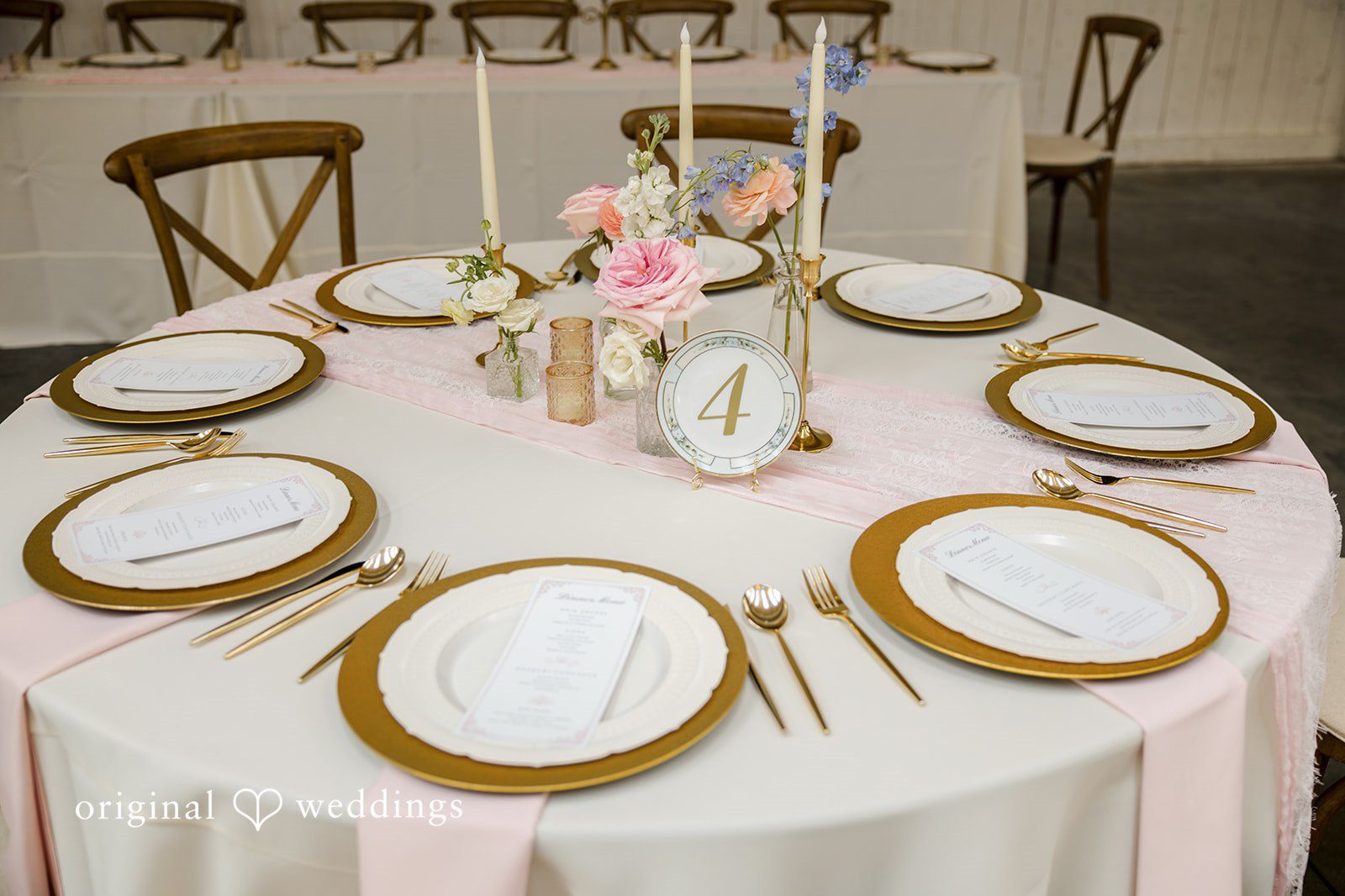 A close-up view highlights a round reception table set with elegant white plates and gold chargers.