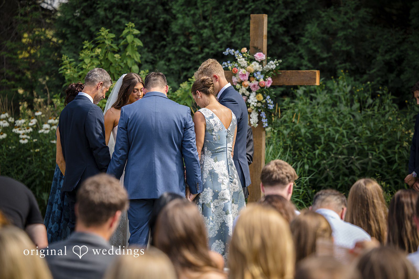 Wedding guests look toward the front during a ceremonial service.