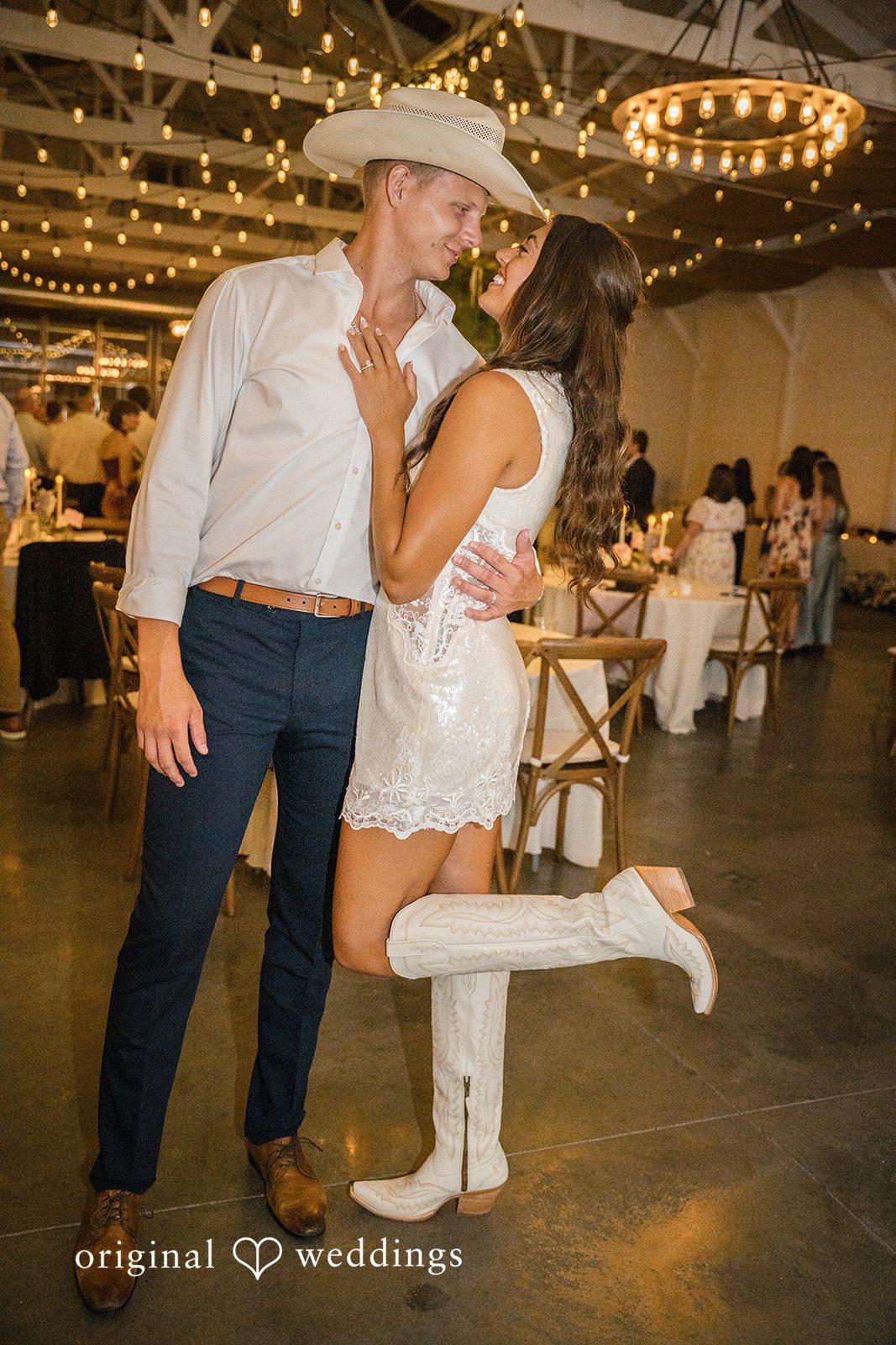 A groom lifts his bride into the air during a lively dance floor moment at the reception.