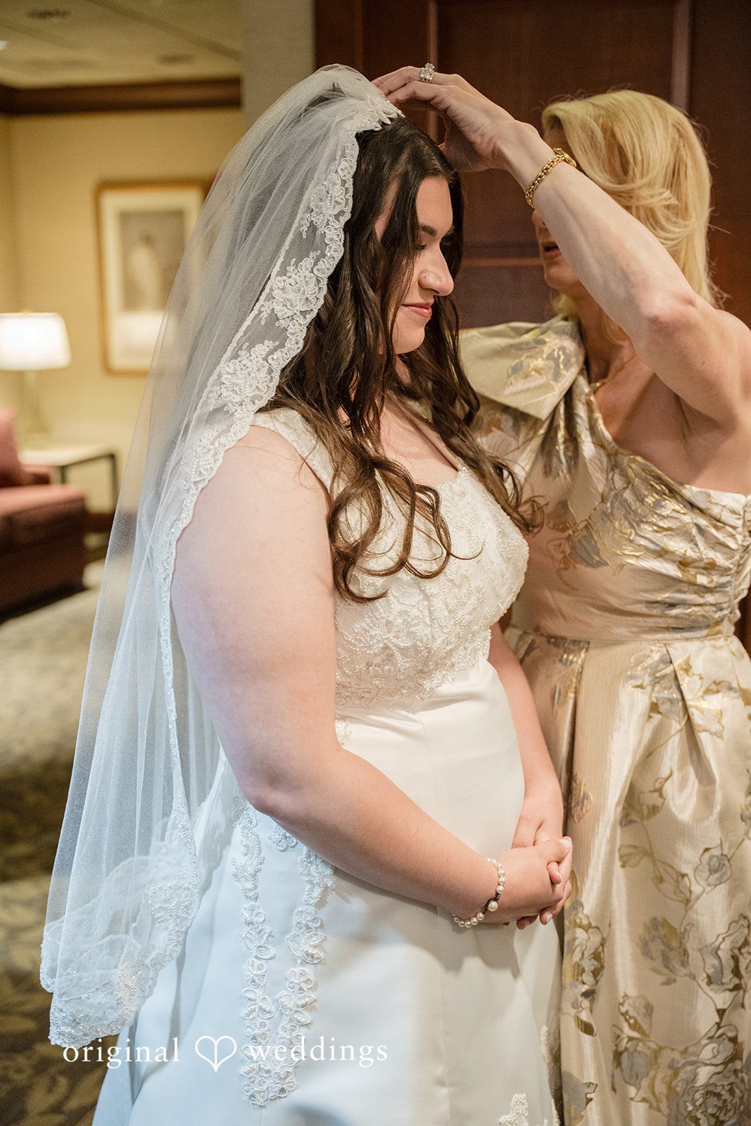 Ava + Zach A bride having her veil adjusted by another woman.